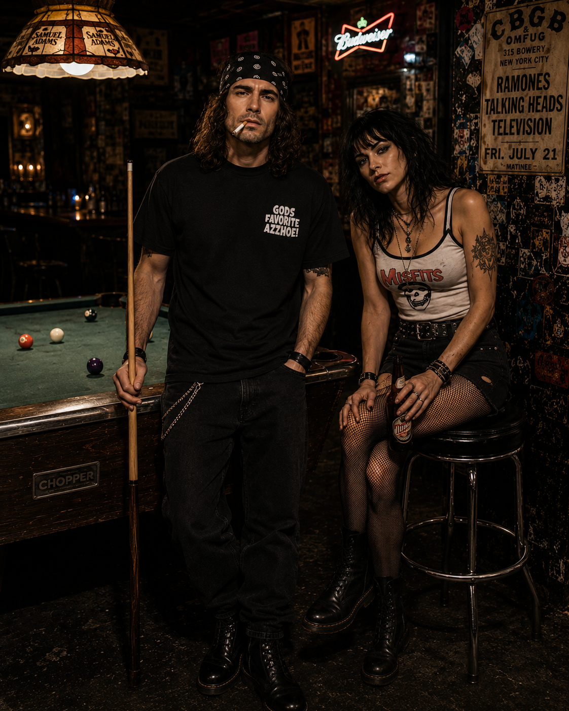Man in black "GODS FAVORITE AZZHOE" t-shirt with woman in Misfits tank top in a dimly lit bar.