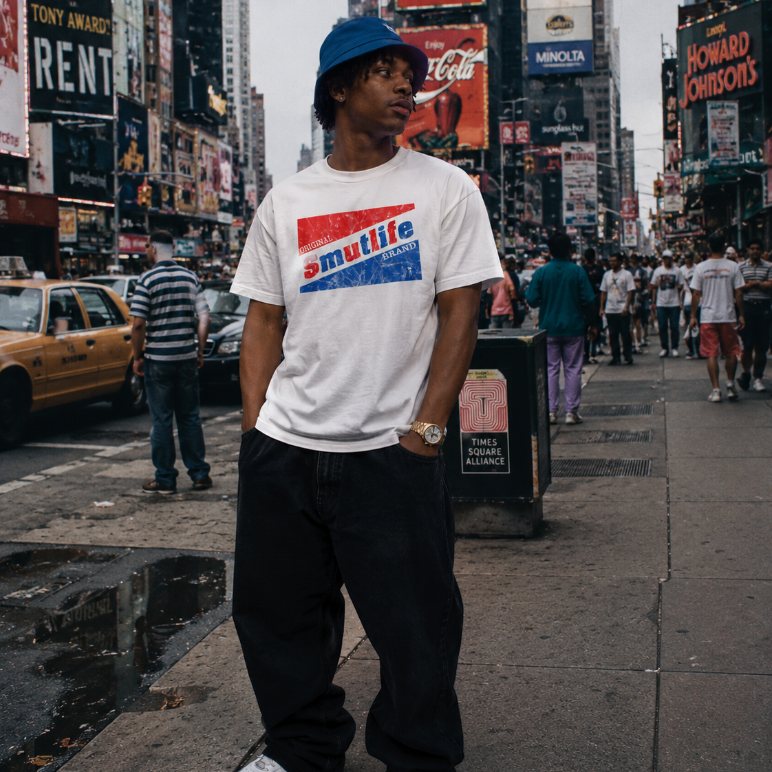 Man in white Smutlife bubble gum t-shirt, black baggy pants, blue bucket hat, and white sneakers in Times Square.