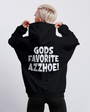 Black "GODS FAVORITE AZZHOE!" pullover hoodie on a person with blonde hair, back view.