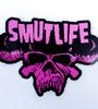 SMUTLIFE SKULL 3"x4" vinyl sticker with pink text and skull design on a black background.