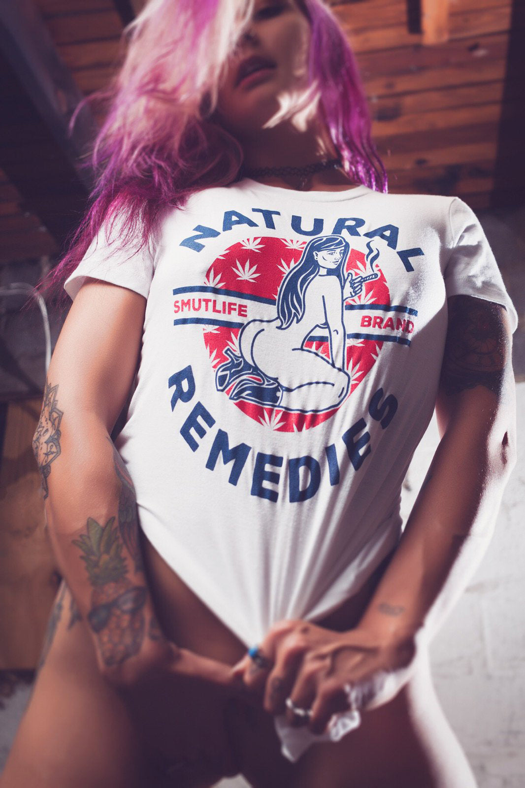 Woman in white SMUTLIFE Natural Remedies Boyfriend T-shirt with cannabis leaf heart design.